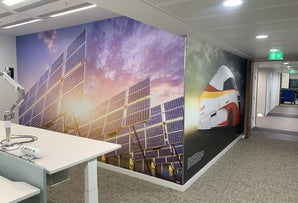 Office wall with large format printed graphics applied across a corner display surface 