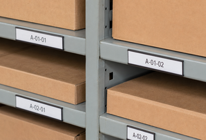 Warehouse shelf labels in magnetic C profile holders for changeable racking and stock location identification.